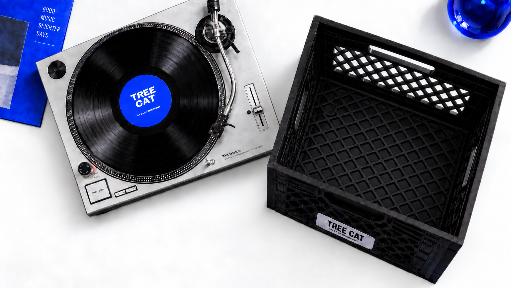 Vista des de dalt: giradiscos i caixa de vinils sobre una taula blanca